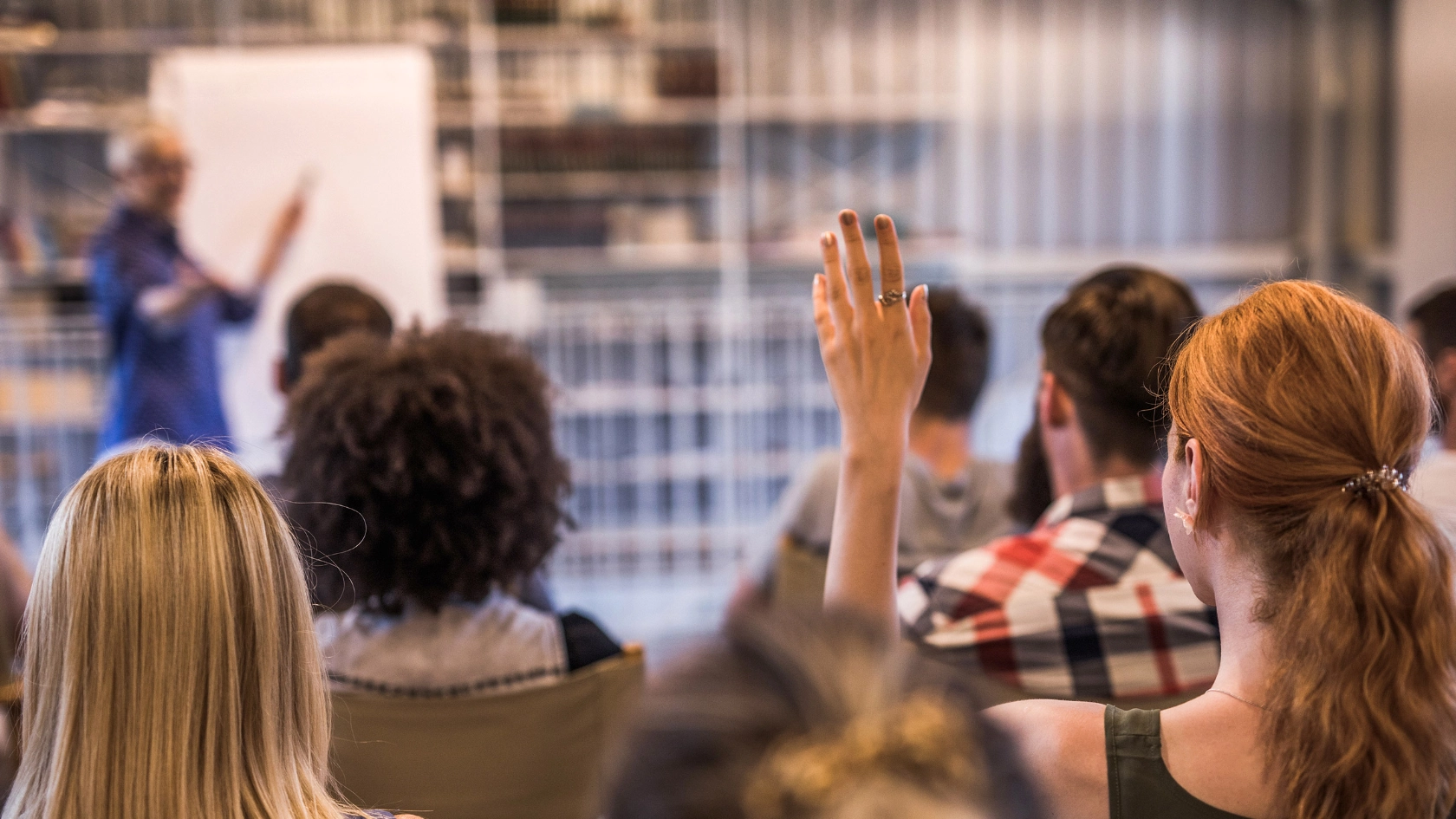 Eine Frau meldet sich während eines Seminars.