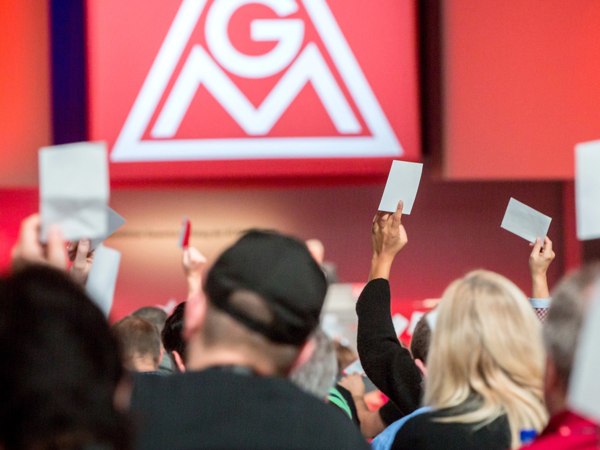 Menschen von hinten, die Abstimmungskarten nach oben halten.